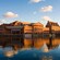 A large neo Gothic brick building with a curviliner awning at the water's edge